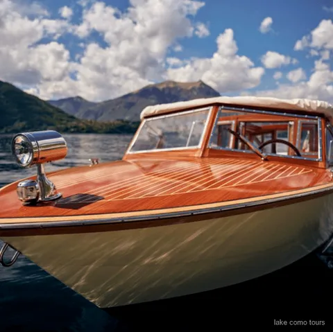 Giro in barca al tramonto sul Lago di Como con luce dorata sull'acqua vicino a Varenna